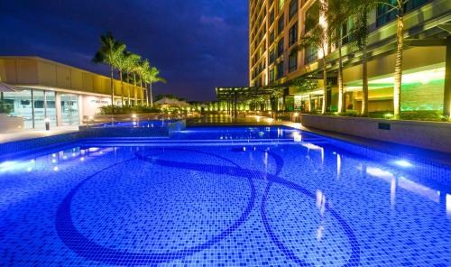 a large swimming pool in front of a building at night at The Light Hotel Penang in Perai