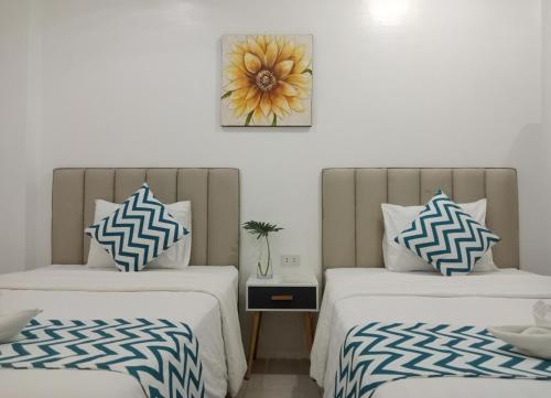 dos camas sentadas una al lado de la otra en una habitación en Grand Blue Beach Hotel, en Boracay