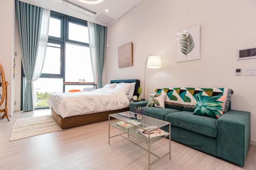 ein Wohnzimmer mit einem Sofa und einem Bett in der Unterkunft Ocean Marina Suite View in Yeosu