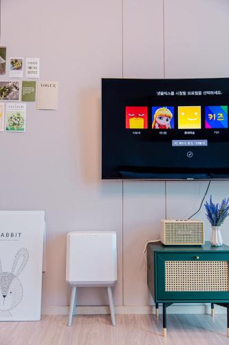 a room with a tv and a chair and a table at Ocean Marina Suite View in Yeosu