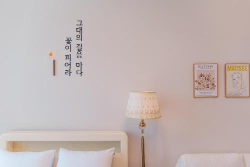a bedroom with a bed and a lamp and a wall at Ocean Marina Suite View in Yeosu