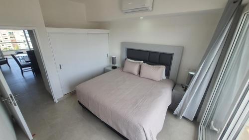 a bedroom with a bed with white sheets and pillows at Hermoso departamento con alberca cerca de la playa in Bucerías