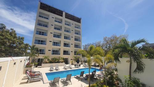 a hotel with a swimming pool and a building at Hermoso departamento con alberca cerca de la playa in Bucerías