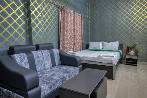 een woonkamer met een bank en een bed bij La Smart Stays in Nāgercoil