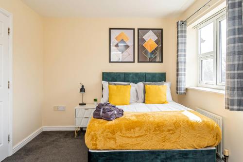 グレート・バーにあるFree Parking Spacious House Near Birminghamのベッドルーム1室(大型ベッド1台、黄色い枕付)