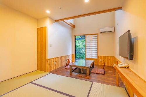 a living room with a table and a tv at Sengokuhara Shinanoki Ichinoyu in Hakone