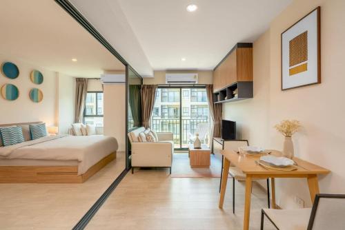 Schlafzimmer mit einem Bett, einem Schreibtisch und einem Tisch in der Unterkunft Lacasita Near Beach Huahin (Room652) in Hua Hin
