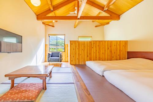 a bedroom with two beds and a table at Sengokuhara Shinanoki Ichinoyu in Hakone