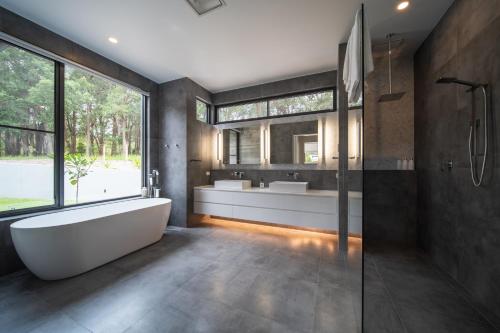 a bathroom with a tub and two sinks at Launa Killcare Heights in Killcare