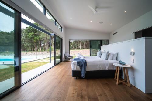 a bedroom with a large bed and sliding glass doors at Launa Killcare Heights in Killcare