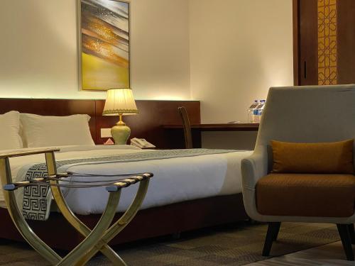 a hotel room with a bed and a chair at Empyrean Dhaka City Centre in Dhaka
