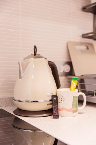 a tea kettle and a cup on a counter at Ocean Marina Suite View in Yeosu