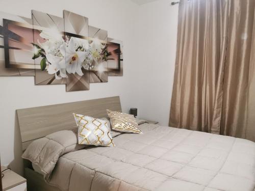 a bedroom with a bed with flowers on the wall at Fondachello "MarEtna" in Mascali