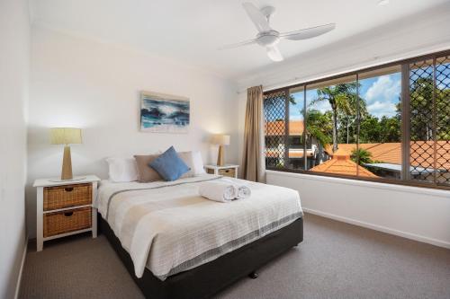 a bedroom with a bed and a large window at Wolngarin Holiday Resort Noosa in Noosaville