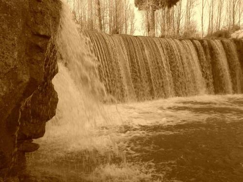 a waterfall in front of a large waterfall at Apartamentos El Prado in Valbona