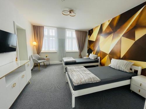 コスヴィッヒにあるAnhalt Pensionのベッド2台とテレビが備わるホテルルームです。