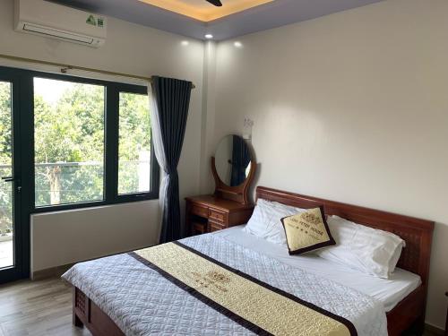een slaapkamer met een bed en een groot raam bij John Peter House in Sầm Sơn