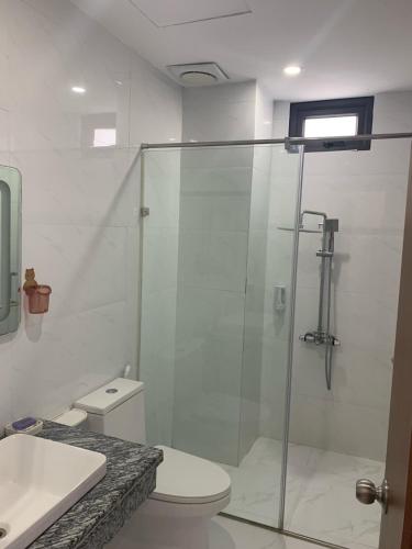 a bathroom with a shower and a toilet and a sink at John Peter House in Sầm Sơn