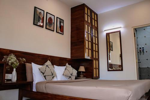 a bedroom with a large bed and a mirror at Casa Mel in Puducherry