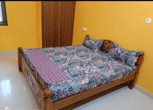 uma cama num quarto com um edredão floral em WHITE HOUSE SERVICE APARTMENT em Madurai