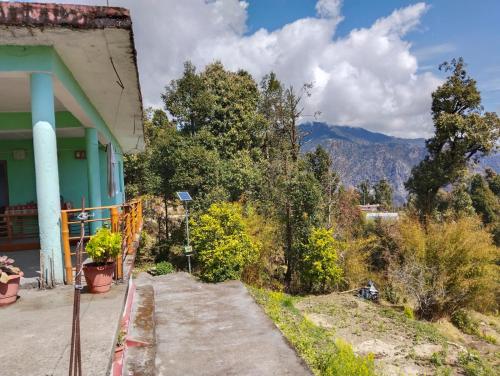 um alpendre de uma casa com uma montanha ao fundo em Shradha Homestay Leeti em Bāgeshwar