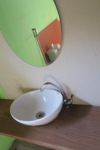 a bathroom sink with a mirror on top of a counter at Samaki Guesthouse - Tad Lo in Ban Donkhagnoung