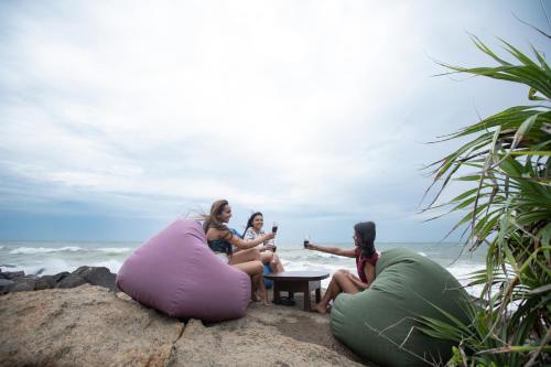 three women sitting in bean bags on the beach at Villa Thuya in Balapitiya