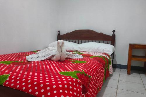 a stuffed animal is sitting on a red bed at Istroberi Inn Palawan near Airport in Puerto Princesa City