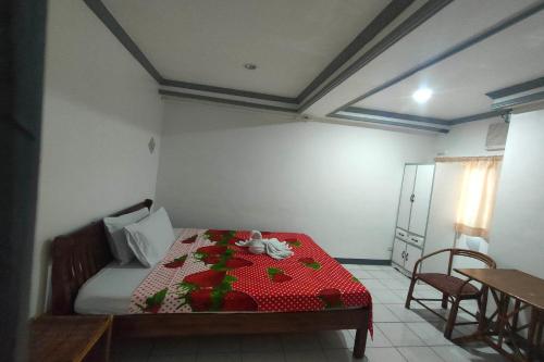 a small room with a bed with a red table at Istroberi Inn Palawan near Airport in Puerto Princesa City