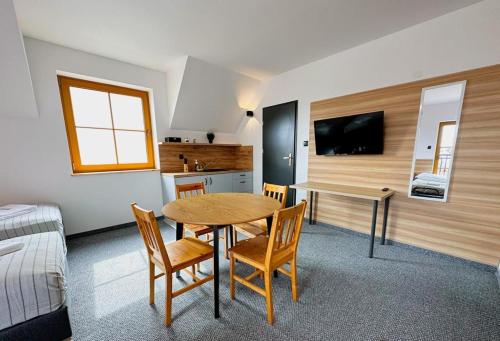 een kamer met een tafel en stoelen en een keuken bij Hotel Czerwone Korale in Cielimowo