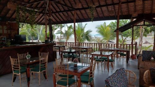 a restaurant with tables and chairs and a bar at La Tranquilidad Twin Beach Resort in Dipnay