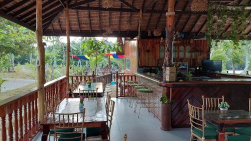 a restaurant with tables and chairs and a bar at La Tranquilidad Twin Beach Resort in Dipnay