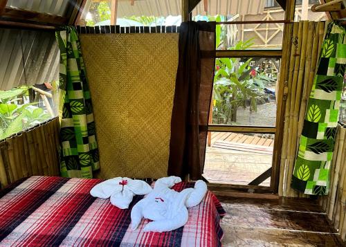 dois bichos de peluche sentados em cima de uma cama em Cabañas Bambután em Palenque
