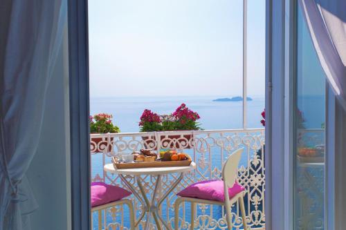 a dining room table with a balcony overlooking the ocean at Casa Nilde in Positano