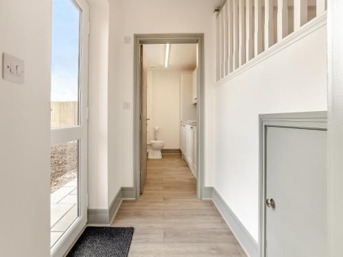 a hallway with a bathroom with a toilet and a window at The Pastures - Uk41853 in Maltby le Marsh