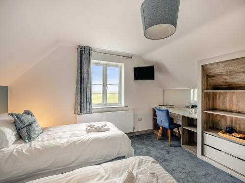 a bedroom with two beds and a desk and a window at The Pastures - Uk41853 in Maltby le Marsh