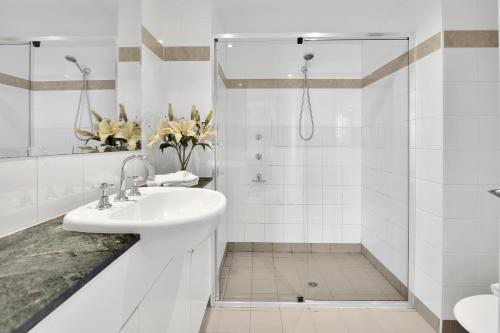a white bathroom with a sink and a shower at Modern spacious Chatswood Apartment H1016 in Sydney