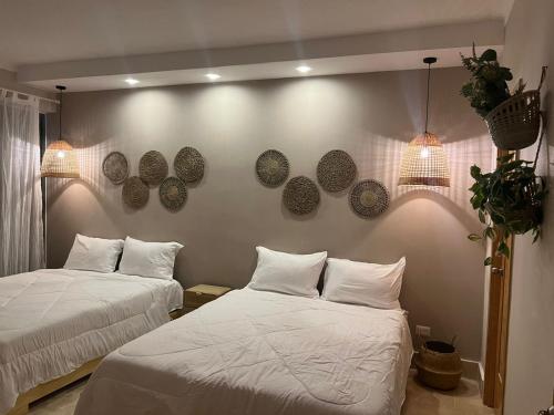 a bedroom with two beds and a wall with plates on it at LUXURY IN LAS TERRENAS AMARE in Santa Bárbara de Samaná