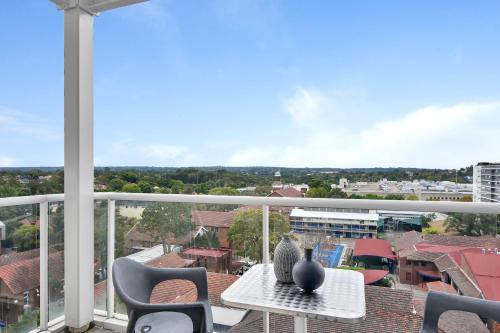 a balcony with a table and chairs and a view at Modern spacious Chatswood Apartment H1016 in Sydney
