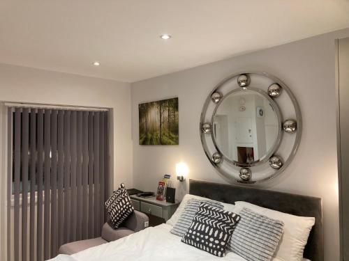 a bedroom with a bed with a mirror and a chair at Beautiful 1-Bed studio in Penrith in Penrith