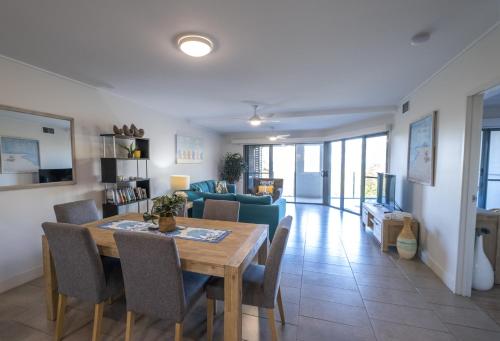 a dining room and living room with a table and chairs at Pavillions on 1770 in Agnes Water