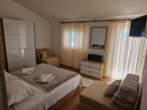 1 dormitorio con cama, silla y espejo en Apartments Jagoda, en Podstrana