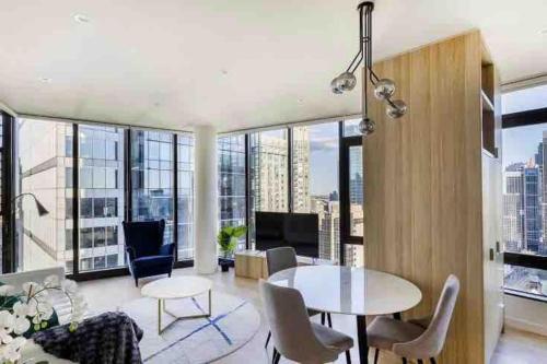 a living room with a table and chairs and large windows at Luxury Stay in Sydney CBD in Sydney