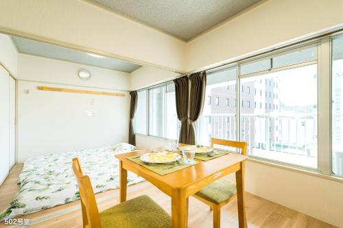 a room with a table and a bed and a window at Nanei Building - Vacation STAY 03606v in Kagoshima