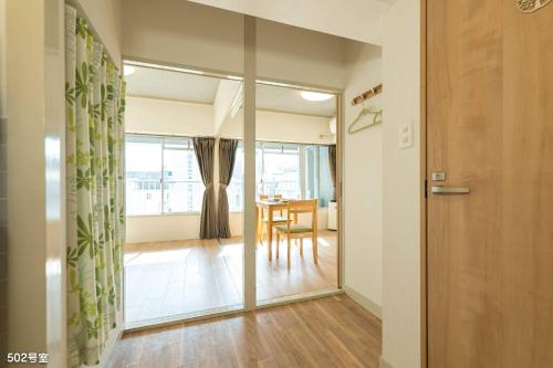 un corridoio con porta e una sala da pranzo con tavolo di Nanei Building - Vacation STAY 03606v a Kagoshima