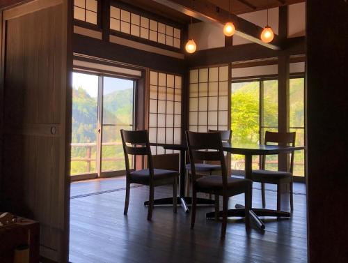 een eetkamer met een tafel en stoelen en een raam bij Tanekura Inn 
