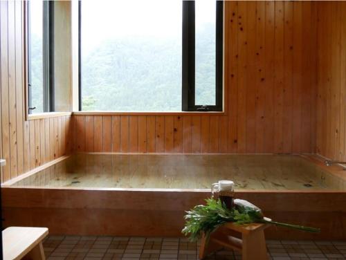een bad in een kamer met een raam bij Tanekura Inn 