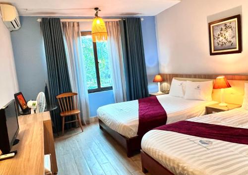 pokój hotelowy z 2 łóżkami i oknem w obiekcie Minh Chau Beach Resort w mieście Quang Ninh
