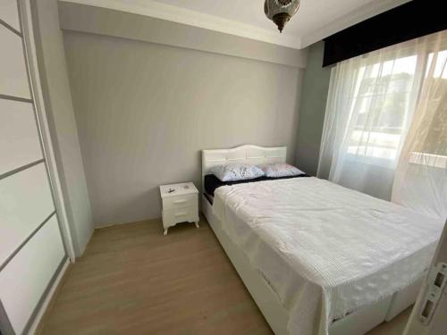 een kleine slaapkamer met een bed en een raam bij Sahile 200 metre uzaklıkta bahçeli dublex Yenifoça in Yenifoça