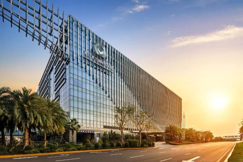 a tall glass building with a road in front of it at Haikou Meilan International Airport Hotel in Haikou